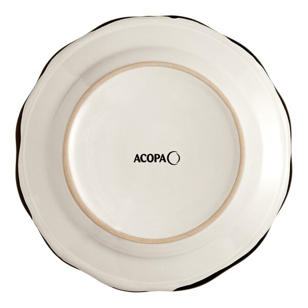 An Acopa ivory stoneware plate with a scalloped edge and black trim.