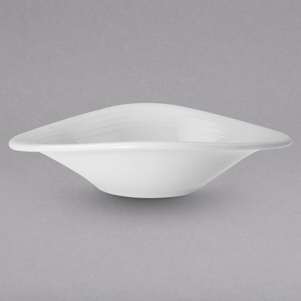 A Villeroy & Boch white porcelain bowl with a curved shape on a gray surface.