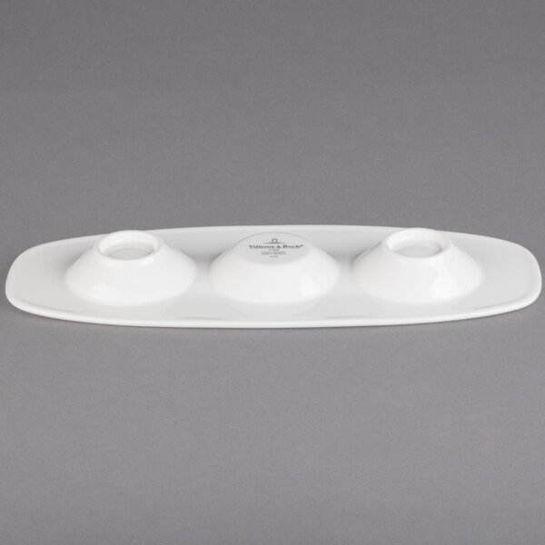 A white porcelain oval plate with three compartments.