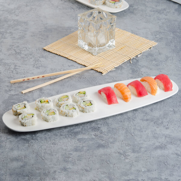 A Villeroy & Boch white porcelain oval plate with sushi and chopsticks on it.