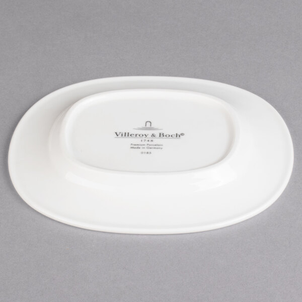A white porcelain oval platter with a logo on it.