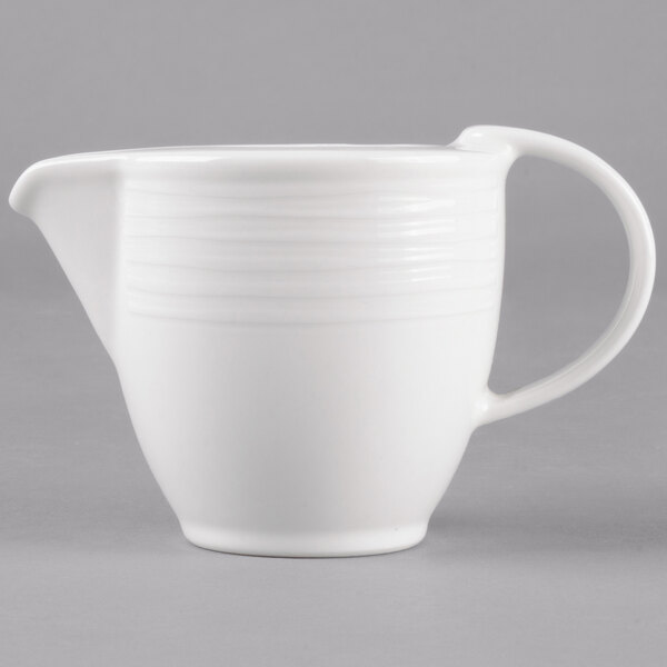 A white Villeroy & Boch porcelain creamer with a handle.
