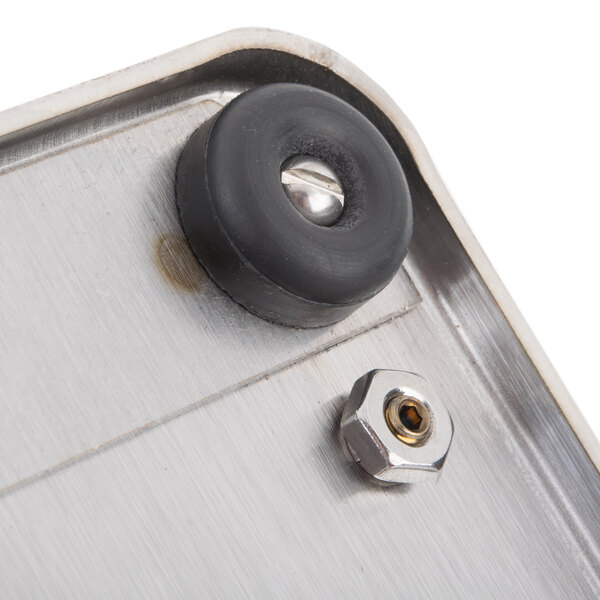 A close-up of a metal plate with black rubber rings.