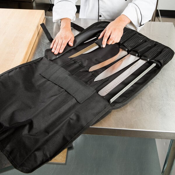 A person holding Dexter-Russell SofGrip cutlery in a black bag.