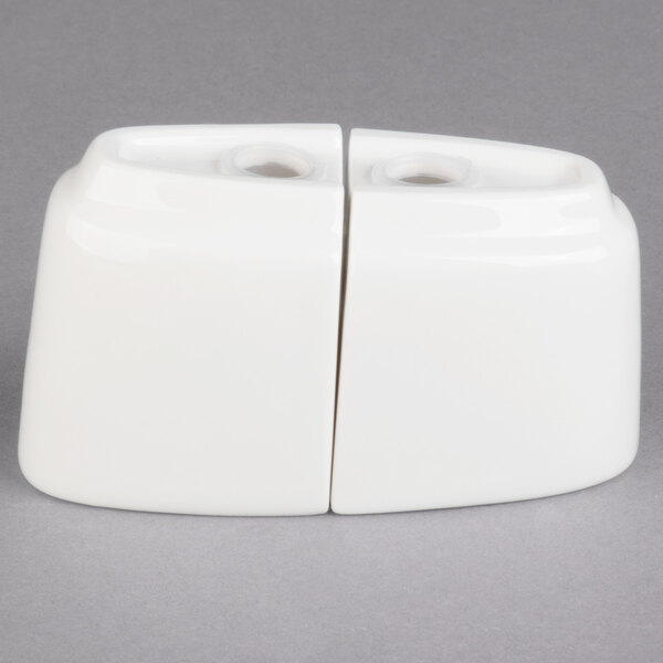 A white ceramic container with two bowls and two holes sitting on top of each other.