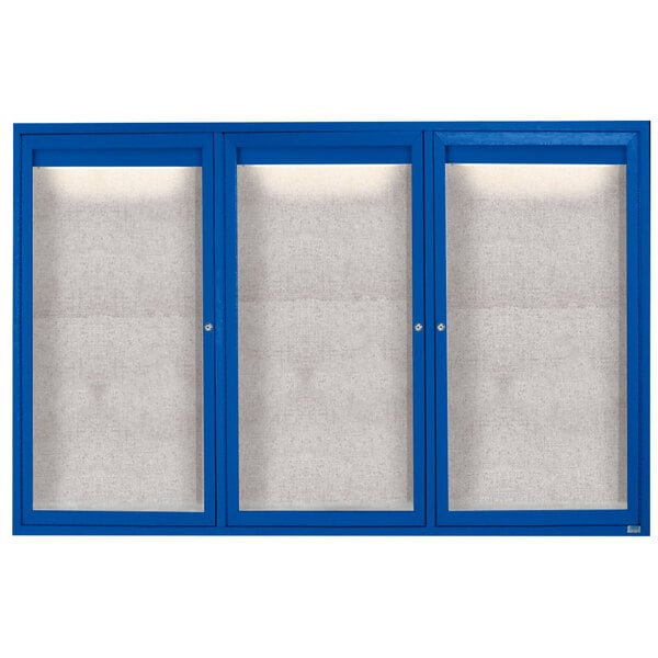 A blue cabinet with three white doors with glass panels.