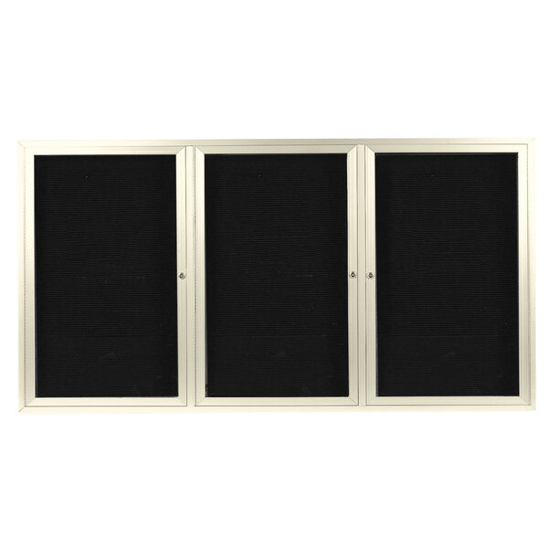 A white rectangular message center with three black doors and a black letter board.