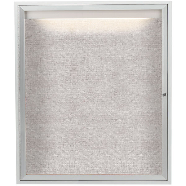 A white framed Aarco bulletin board cabinet with a light on it.