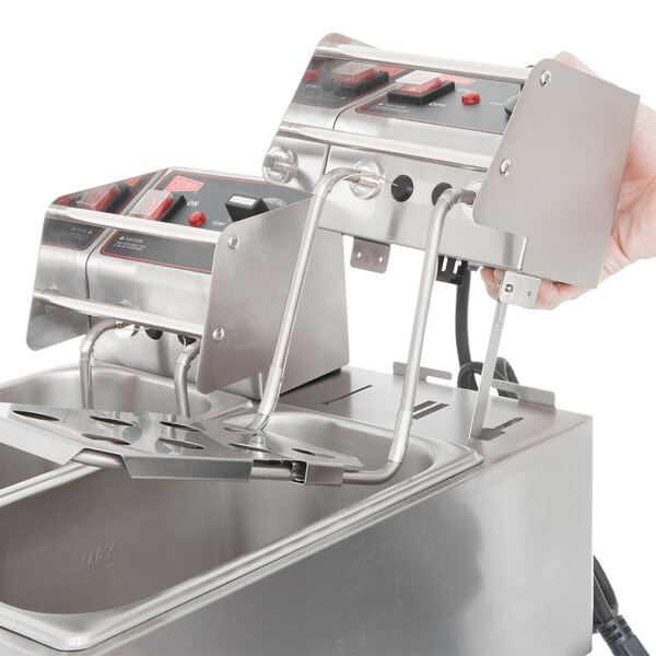 A person using a Cecilware stainless steel electric countertop deep fryer on a counter.
