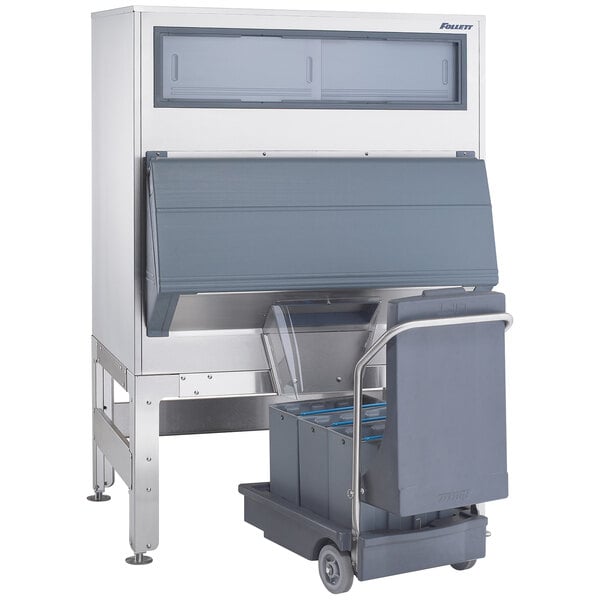 A grey rectangular Follett ice storage bin with a rectangular ice cart inside.