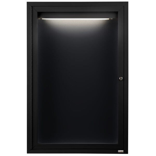 A black cabinet with a light on it and a black framed door.