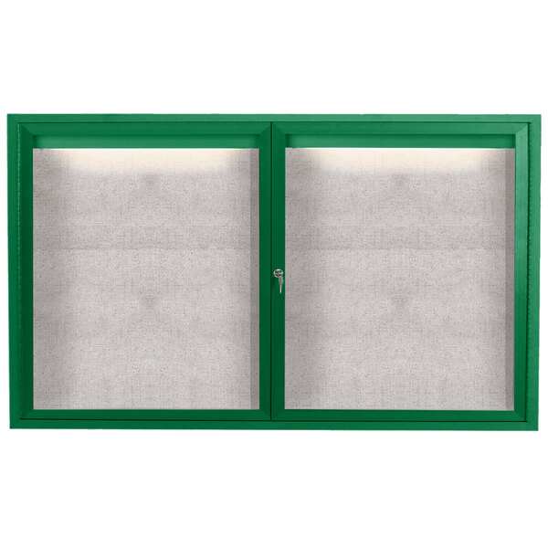 A green enclosed bulletin board cabinet with two glass doors with white windows.