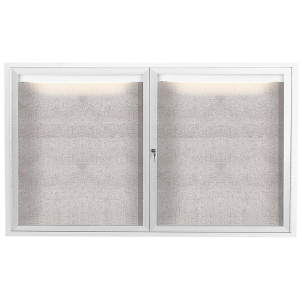 Two white Aarco enclosed bulletin board cabinets with glass doors.
