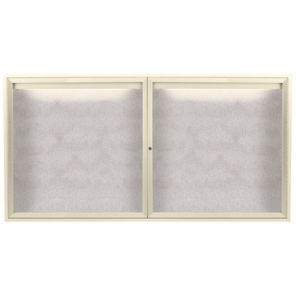 An ivory powder coated metal bulletin board cabinet with two doors and a white screen with a light on it.