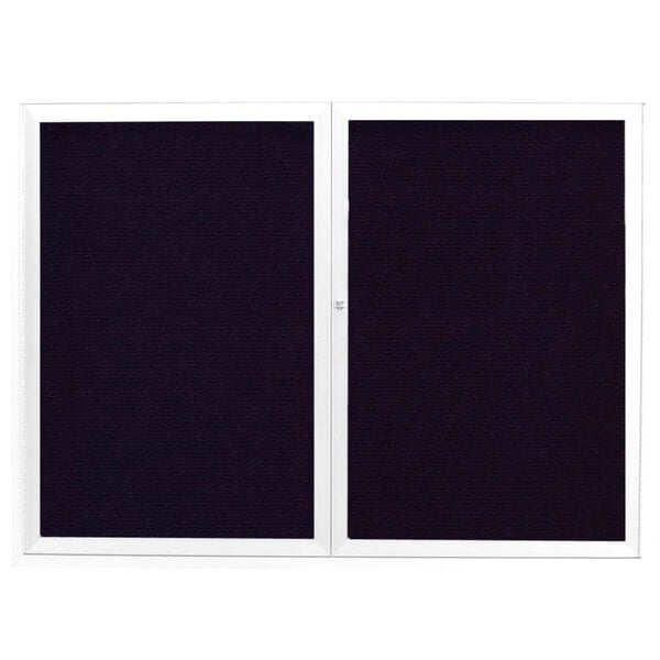 A white rectangular Aarco message center with two black rectangular doors with white borders.