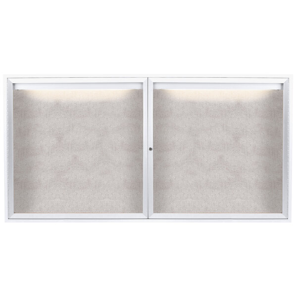 A white framed bulletin board with two enclosed glass doors.