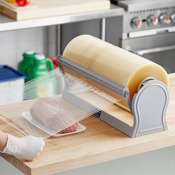 A person packing meat on a counter using Western Plastics meat wrapping film.