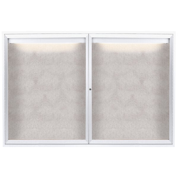 A white powder coated Aarco outdoor bulletin board with two enclosed glass doors.