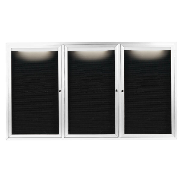 A white rectangular cabinet with three black doors with white borders containing black letter boards.