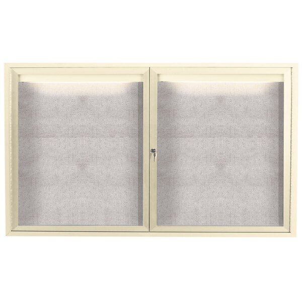 A white enclosed Aarco bulletin board cabinet with two doors.