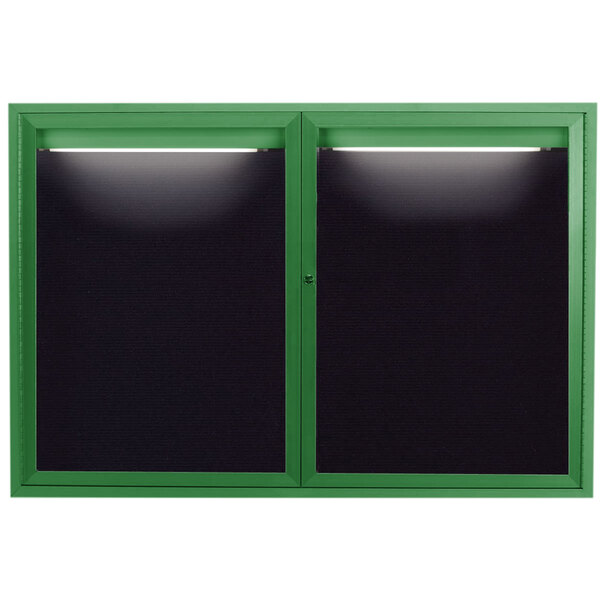 A green framed window with a black letter board inside and lights on top.