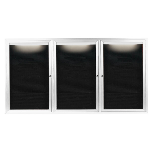 A white rectangular cabinet with three black doors with white frames containing black letter boards.