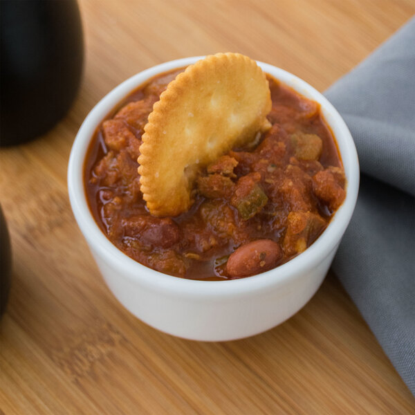 A white Villeroy & Boch porcelain bowl filled with chili and a cracker on top.