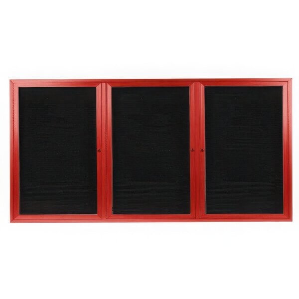 A white rectangular message center with red frame and three black doors.