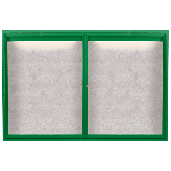 A green Aarco outdoor bulletin board cabinet with two white enclosed glass doors.