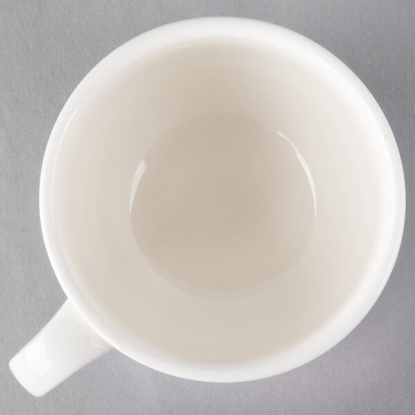 A Villeroy & Boch white porcelain cup with a handle on a gray surface.