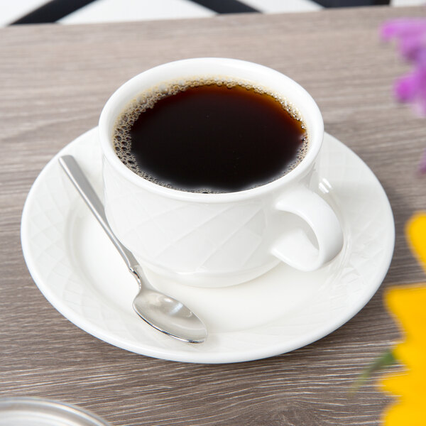A Villeroy & Boch Bella white porcelain cup of coffee on a saucer with a spoon.