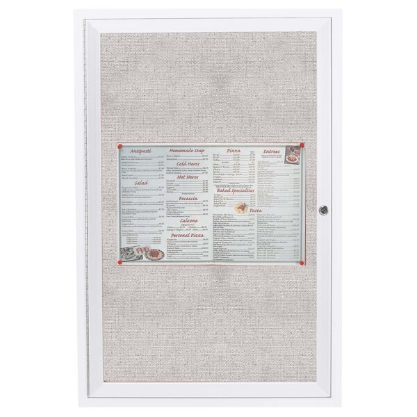 An Aarco white outdoor bulletin board with a menu on it.
