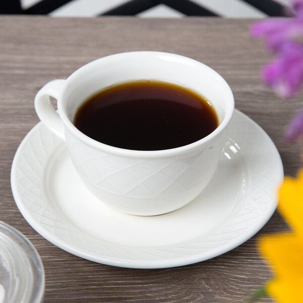 A cup of coffee sits on a Villeroy & Boch white porcelain saucer.