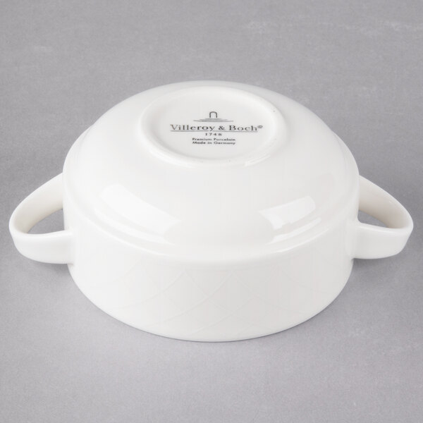 A white porcelain bowl with handles.