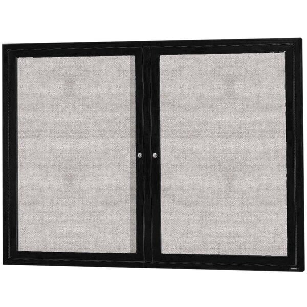 A black Aarco outdoor bulletin board cabinet with two hinged doors and glass panels.