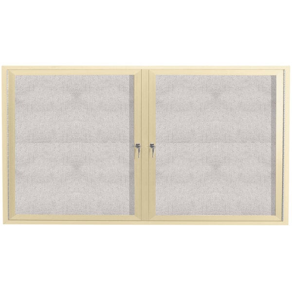 An Aarco ivory outdoor bulletin board cabinet with two doors with glass panels.