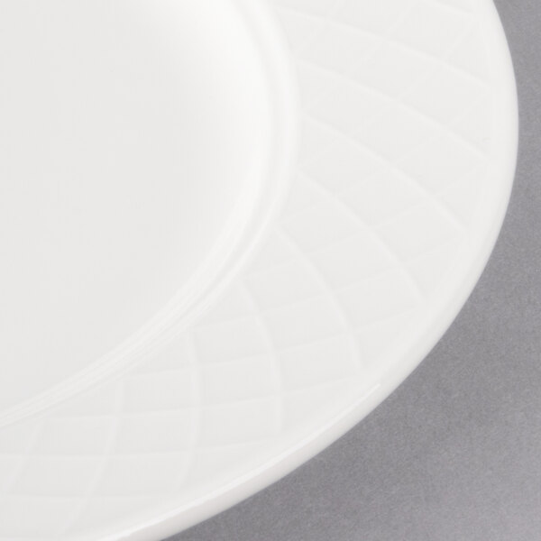 A close-up of a white Villeroy & Boch Bella porcelain plate with a circular design.