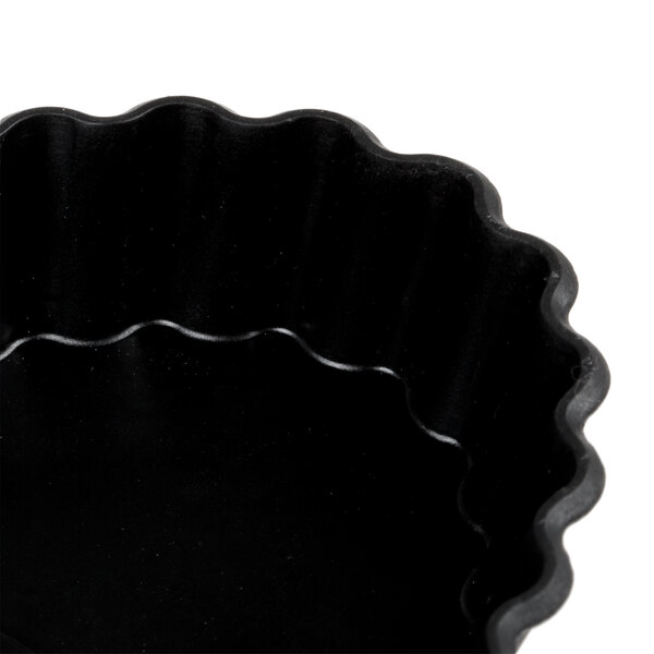 A black fluted oblong tartlet pan.