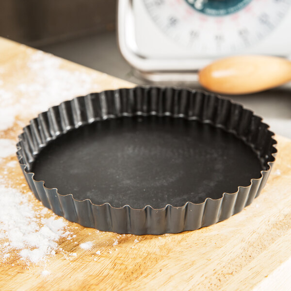 A Matfer Bourgeat fluted black steel tart pan.