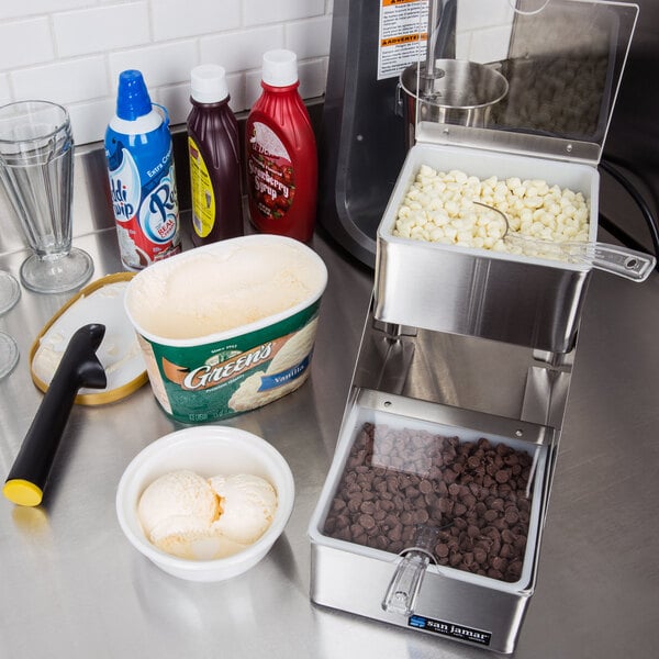 A San Jamar stainless steel condiment bar on a counter in an ice cream shop.