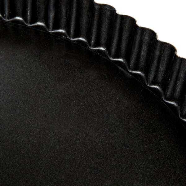A close up of a Matfer Bourgeat fluted non-stick tart pan with a removable bottom.