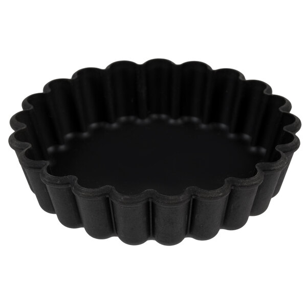 A close-up of a black fluted Matfer Bourgeat tartlet pan.