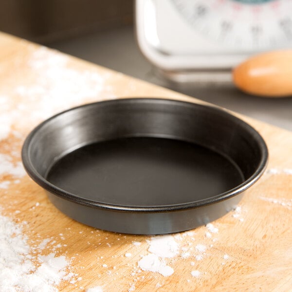 A Matfer Bourgeat quiche pan on a wood surface.