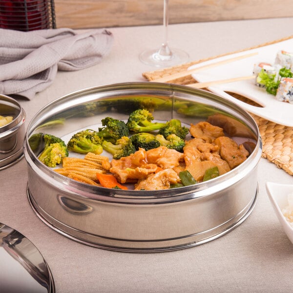 A Town stainless steel dim sum steamer with food inside on a table.