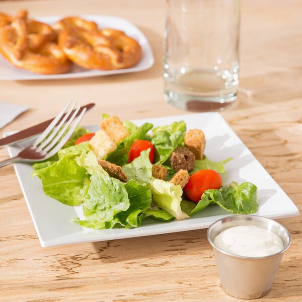a fork on a plate with lettuce and tomato