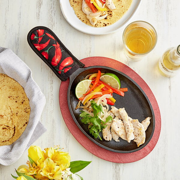 A Lodge cast iron fajita skillet with food on a table.