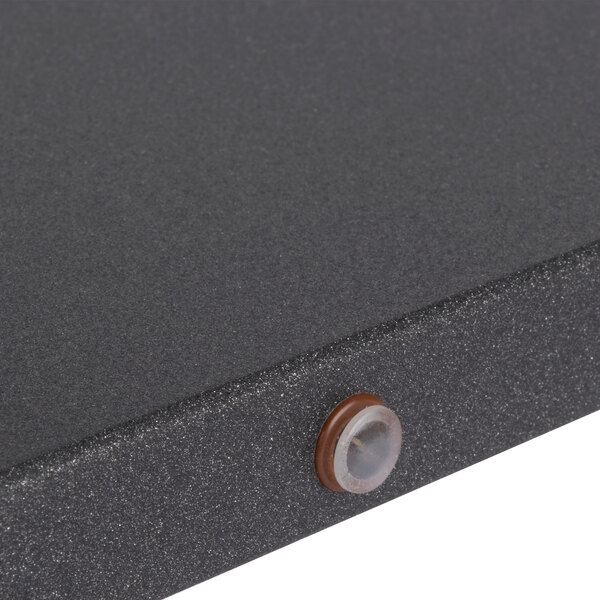 A close up of a black wood long crossbar with a circular button.