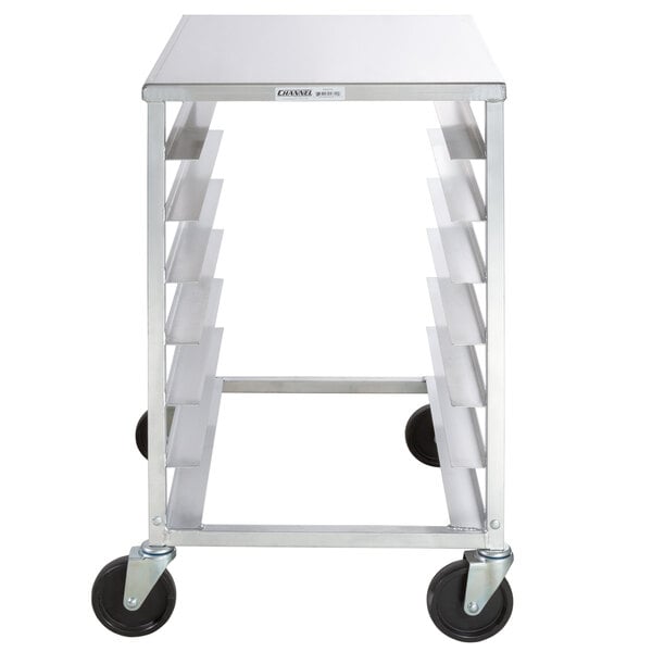 A stainless steel Channel pizza dough box rack with black wheels.