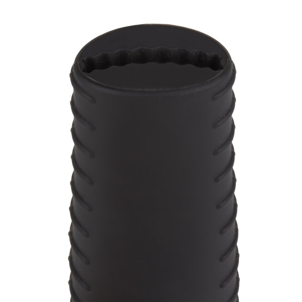 A black cylindrical silicone handle holder for a Lodge skillet.