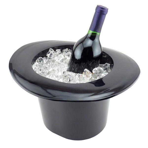 A bottle of wine in a black hat shaped wine bucket filled with ice.